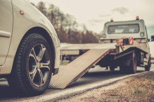 Car Accident Lawyer Pearland, TX - Loading broken car on a tow truck on a roadside
