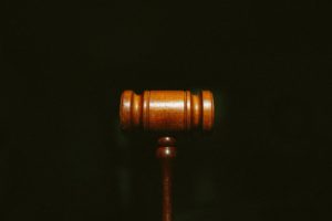 What you Need to Know About Tort Law - A wooden gavel centered on a dark background with grain.