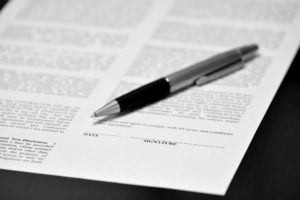 Breach of Contract Attorney Pearland, TX - Contract wtih Pen on Desk Business Transaction