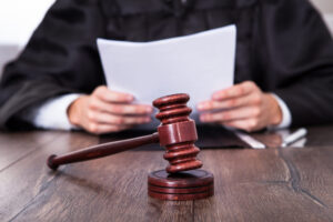 Gavel on a desk in front of a judge holding a document from a Domestic Violence Defense Lawyer Houston, TX